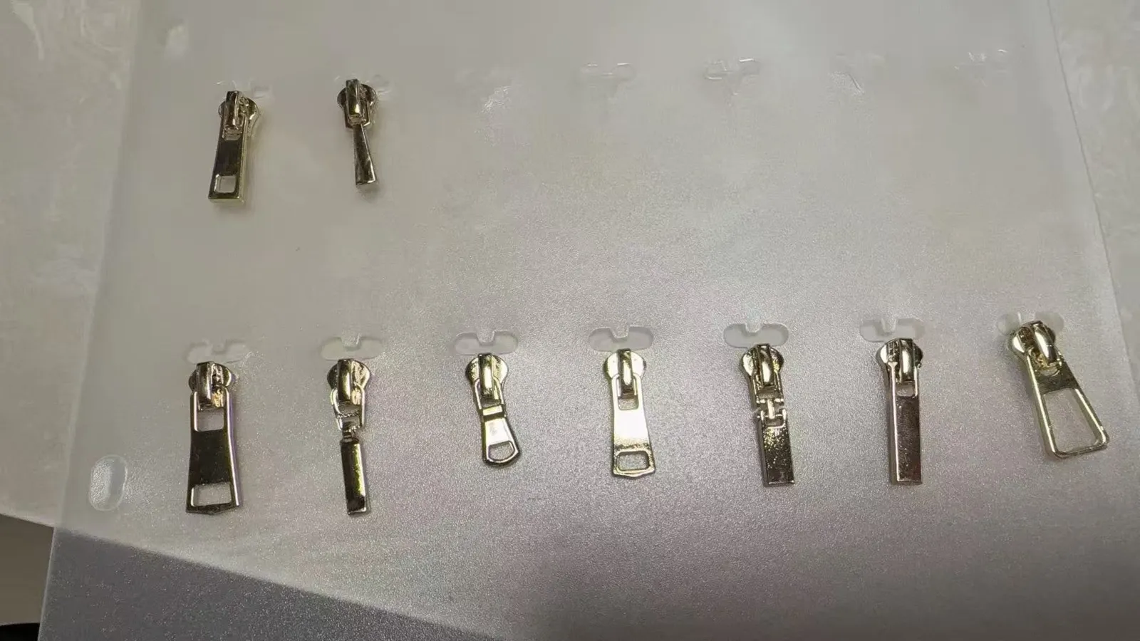 Reihe von Zipper-Pullern mit Logo in verschiedenen Formen