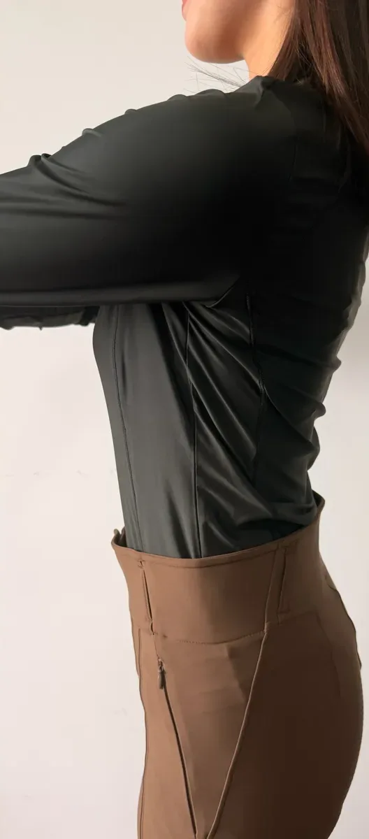 Langärmeliges Reitshirt bei der Anprobe, Seitenansicht mit Seitennaht, getragen zu einer braunen Reithose