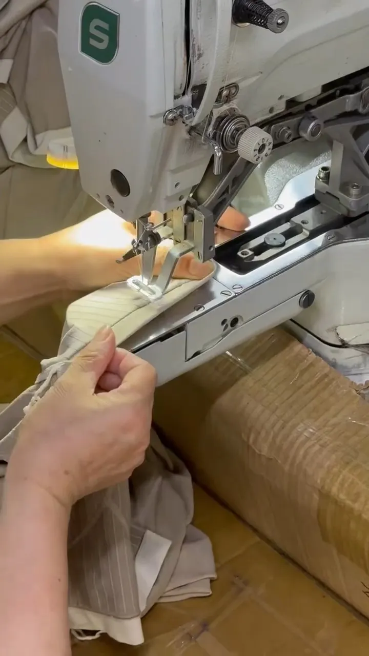 Riegelnaht-Maschine setzt eine Riegelnaht am Bund einer hellen Reithose